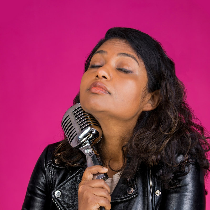 Sharlin Jahan Female Comedian London holding microphone